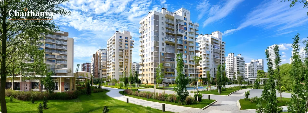 Modern apartment complex with white high-rise buildings, green lawns, and winding pedestrian paths under a blue sky.